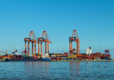Cảng container với cần cẩu và tàu hàng, nơi puree đóng phuy vô trùng được xuất khẩu