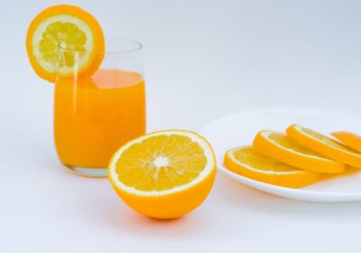 Nước cam tươi bên cạnh cam và chanh cắt lát